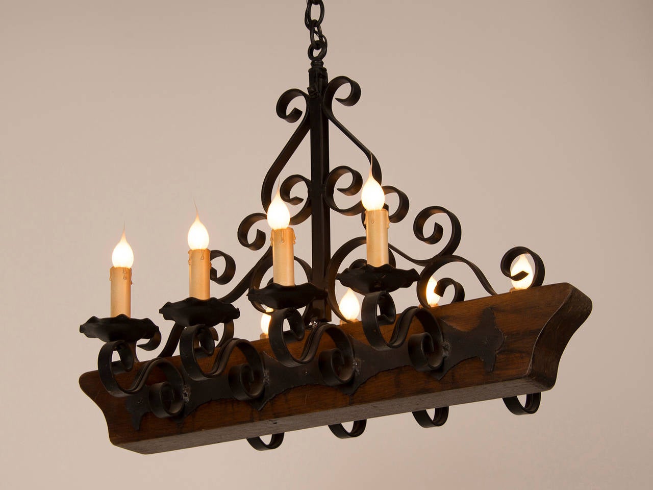 French Decorative Chandelier with a Wooden Beam and Iron Candle Arms, France circa 1950 For Sale