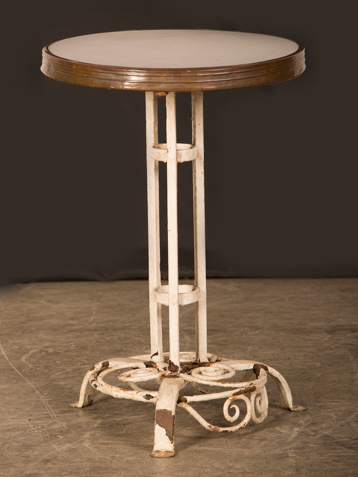 A strikingly painted iron cafe table from Munich, Germany c. 1910. This table retains its original painted finish and it is possible to see the iron underneath the paint at the base of the table. The central column has three vertical supports joined