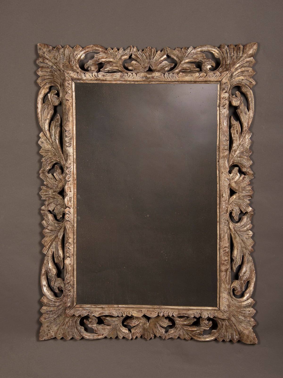 Silvered Carved Oak Mirror, France c.1890. This frame is notable for its unusual combination of carving that accentuates the pierced effect of the open areas between the carved elements. In addition the frame itself is set at an angle to the plane