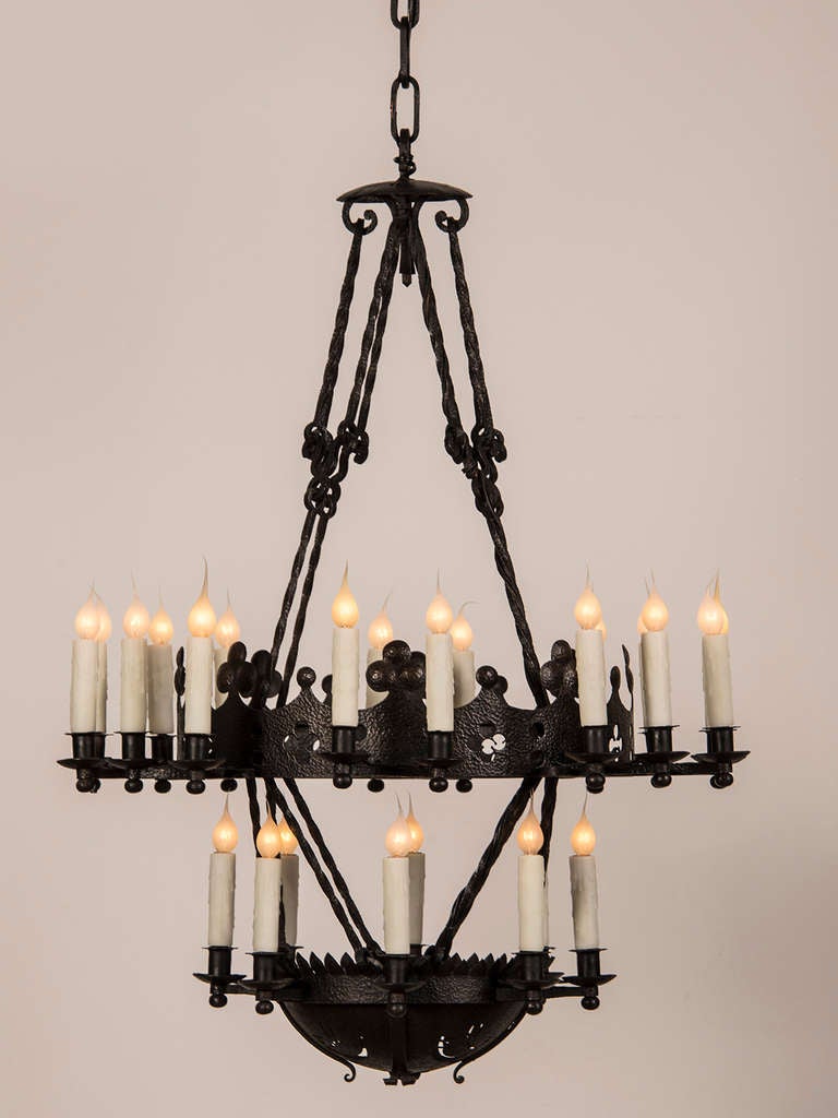 A tall two tier hand forged iron chandelier with twenty four lights from France c.1900. This outstanding example is the work of an individual ironmonger who made each piece individually before assembling this enormous fixture for a large country