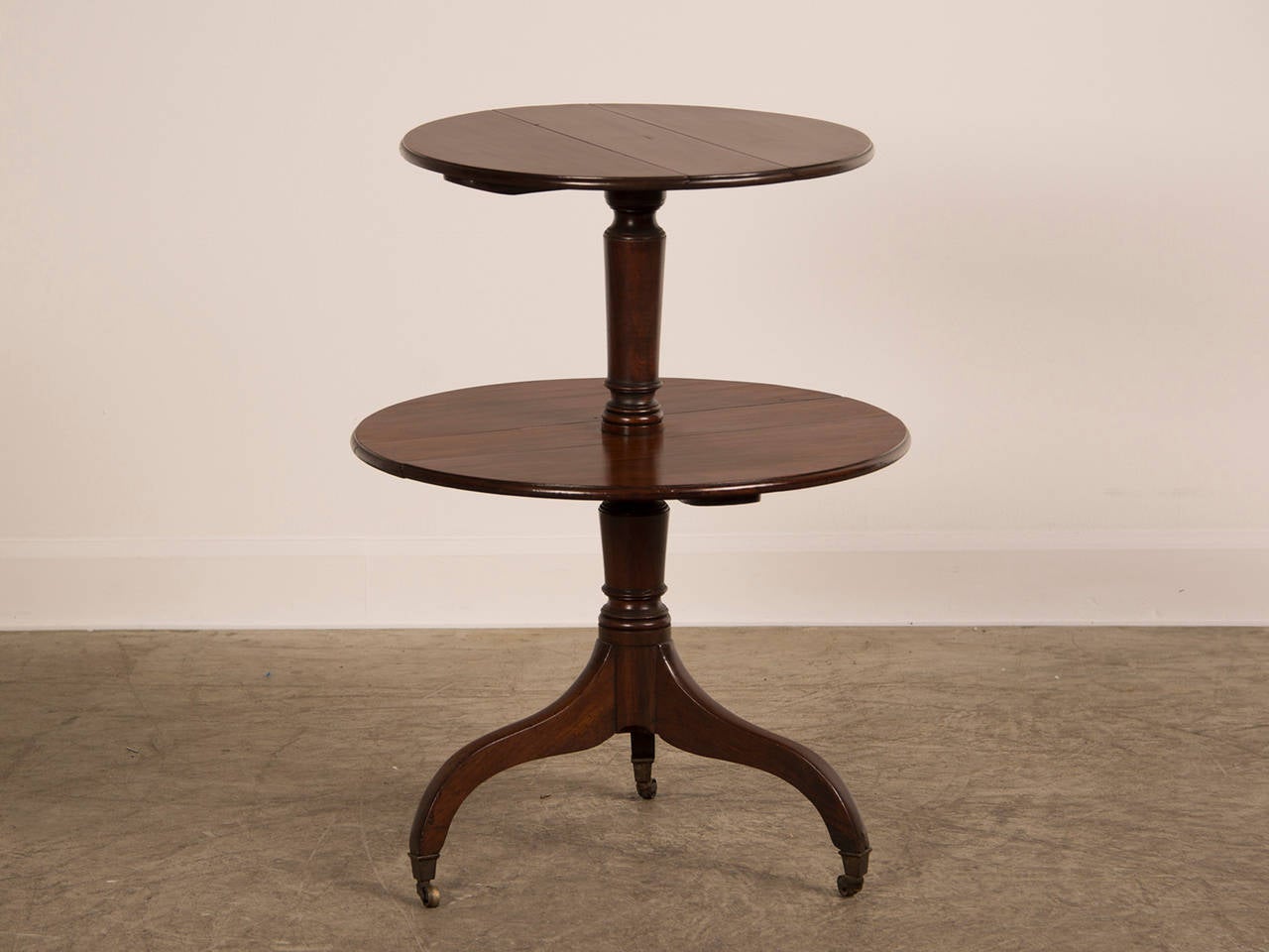 A beautiful George III period mahogany pedestal table having two levels, each with drop leaves on a tripod base from England c. 1820.
