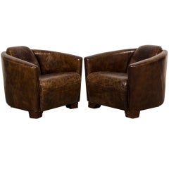 A pair of handsome Art Deco style armchairs from Italy covered in leather.