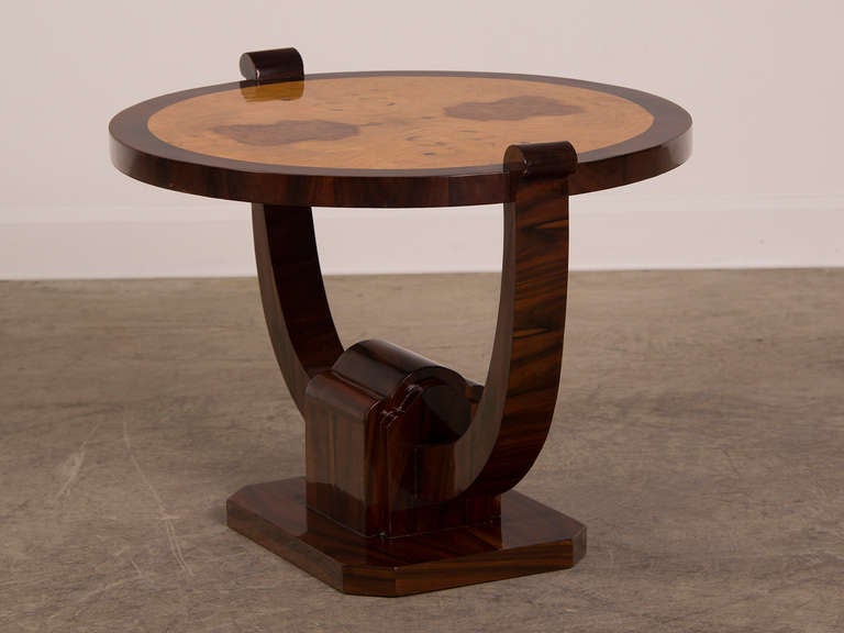 A circular Art Deco period table with rosewood and burl ashwood standing upon a shaped base inspired by the designs of Ruhlmann from France c. 1930.