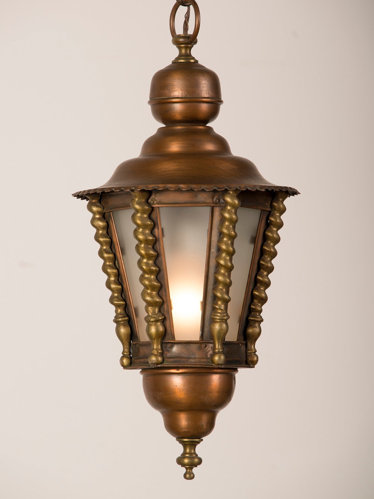 A charming brass and copper hall lantern from France c. 1920 having panes of frosted glass.