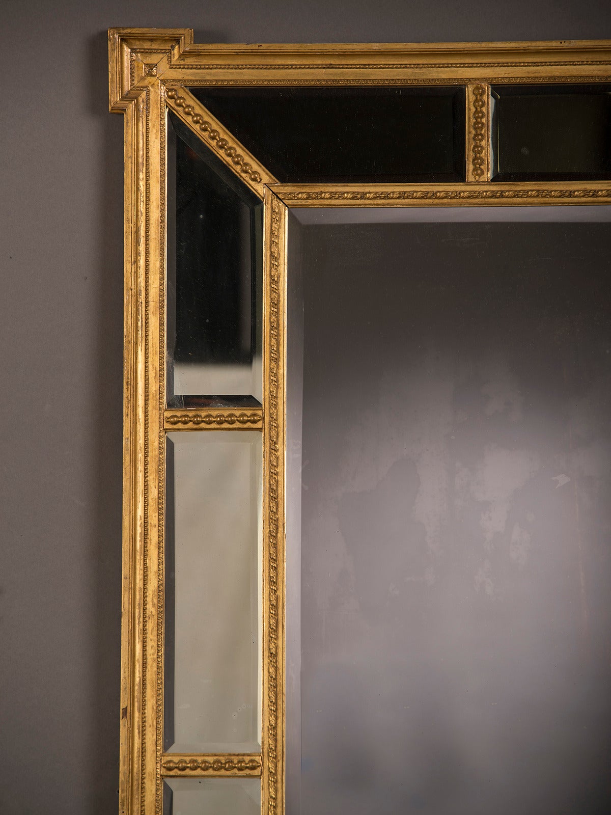 A handsome gold leaf frame in the manner designed by famed English architect Robert Adam (1728-1792) that encloses the mirror glass from England circa 1895. Please notice the unusual shape of this frame with its straight sides that meet each corner