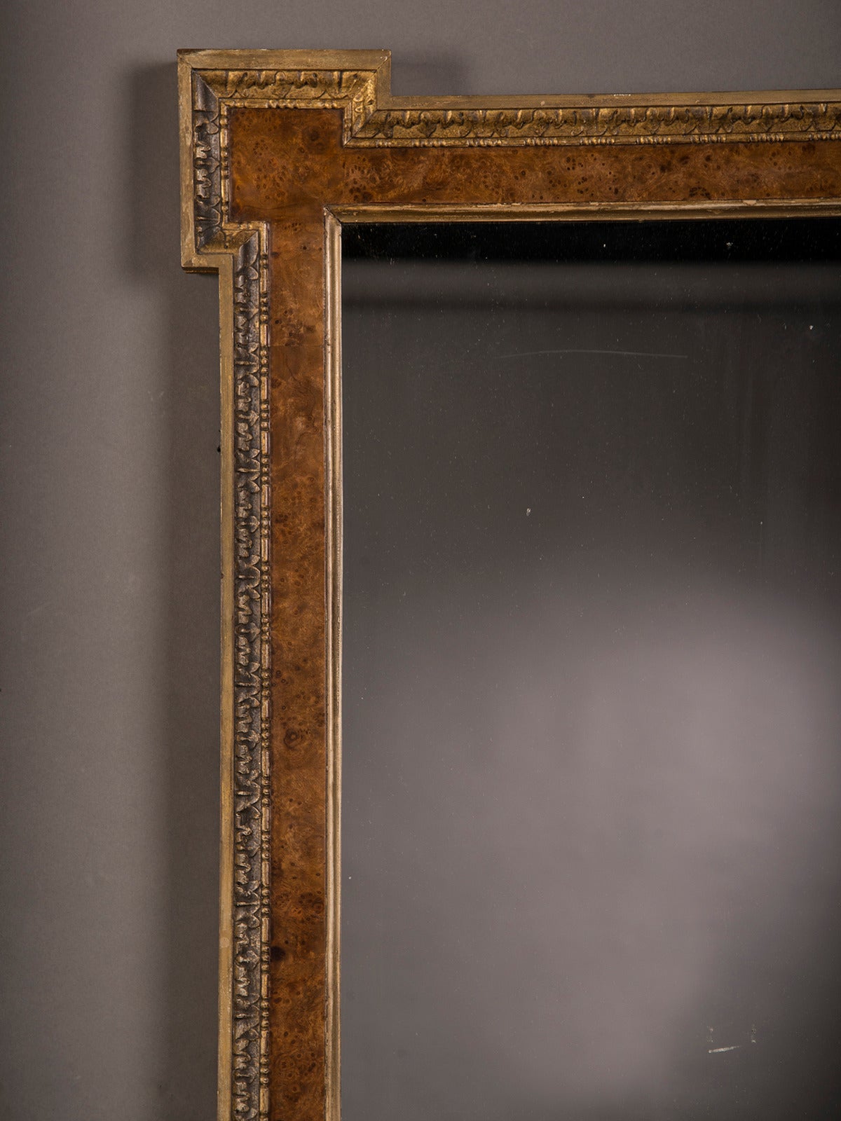 A grand William Kent style burl elm and gilded frame from England circa 1875 enclosing the original mirror glass. This bold frame possesses the characteristic architectural styling for which William Kent became famous in the early eighteenth