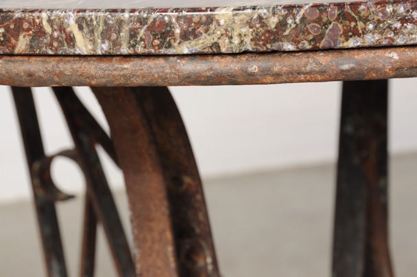 French Iron base dining table with a marble top from France c. 1890