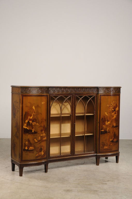 A tall painted buffet/ display cabinet from England c. 1930. Please notice the enticing form of this unusual piece. Both of the cabinet doors on the left and right are bowfront shaped and flank a pair of cabinet doors in the centre that feature