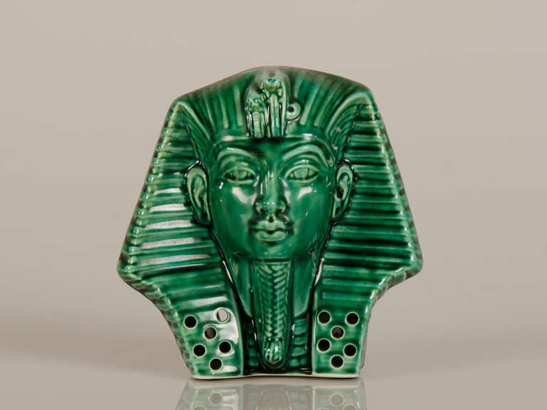 A green glazed bisque porcelain pastille (incense) burner shaped as the head of a Pharaoh from France c.1880. This piece represents an artifact from the nineteenth century France that reflects the ongoing fascination with Egyptian culture ever since