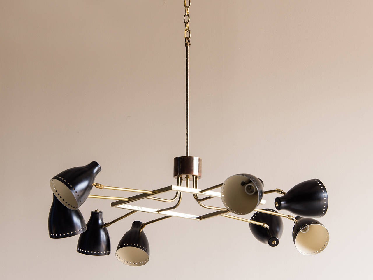Vintage Mid-Century eight-arm square brass and steel chandelier from Italy, circa 1960. The unusual arrangement of the eight lights features two arms on each of the four sides with each black metal shade being able to pivot in a desired direction to