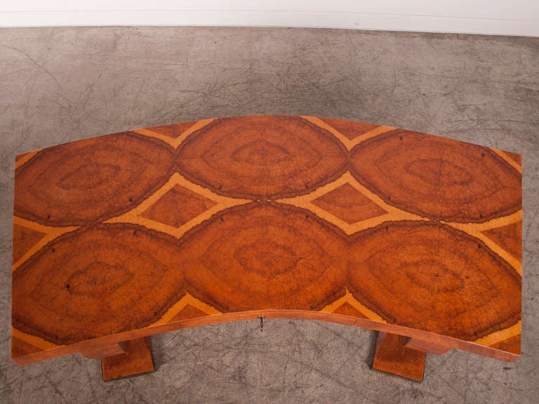 A Jaacues-Emile Ruhlmann style Art Deco writing table with a curved front and one drawer featuring a stunning amboyna burl top from France c.1930. This superb table follows the design of Jacques Emile Ruhlmann, one of the most influential designers