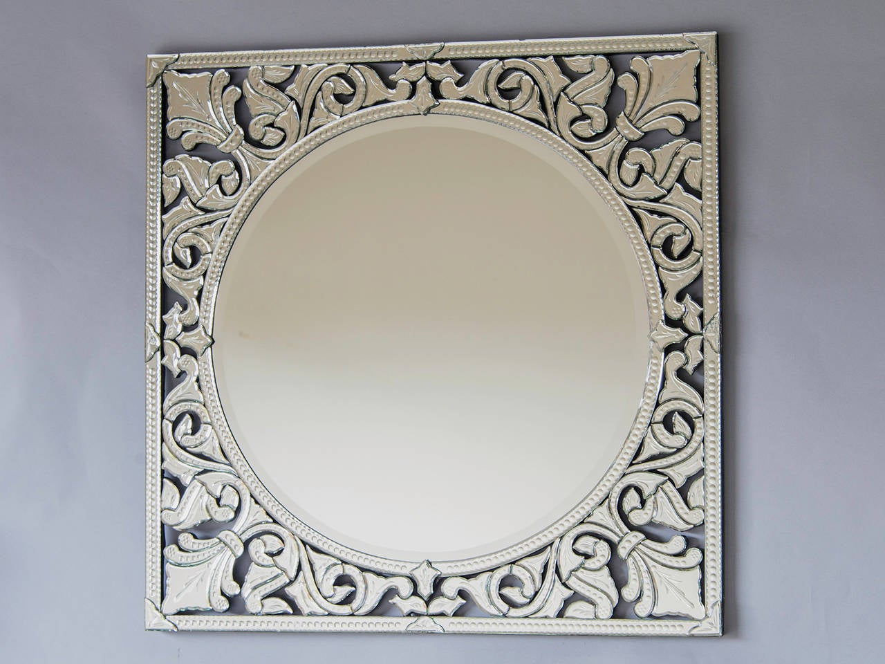 Pair of square Venetian mirrors, Italy. These highly decorative Venetian mirrors feature an unusual shape with all of the cut and pierce work design contained within a square frame. The circular centre mirror is surrounded by a symmetrical