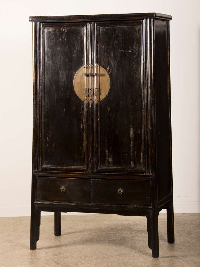 A black lacquer two door cabinet from the Kuang Hsu period in China c.1875 with a tapered profile. The simplicity of the shape of this cabinet gives it a modern air and enables it to be used in a wide variety of interiors. The entire cabinet is
