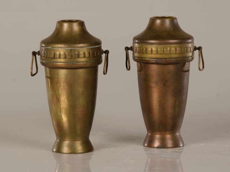 A pair of French copper urns with brass circa 1910. The lovely profile of these urns is quite enchanting as are the small ring handles placed on the opposite sides of each urn. Please note the subtle difference in colour on each of the urns that