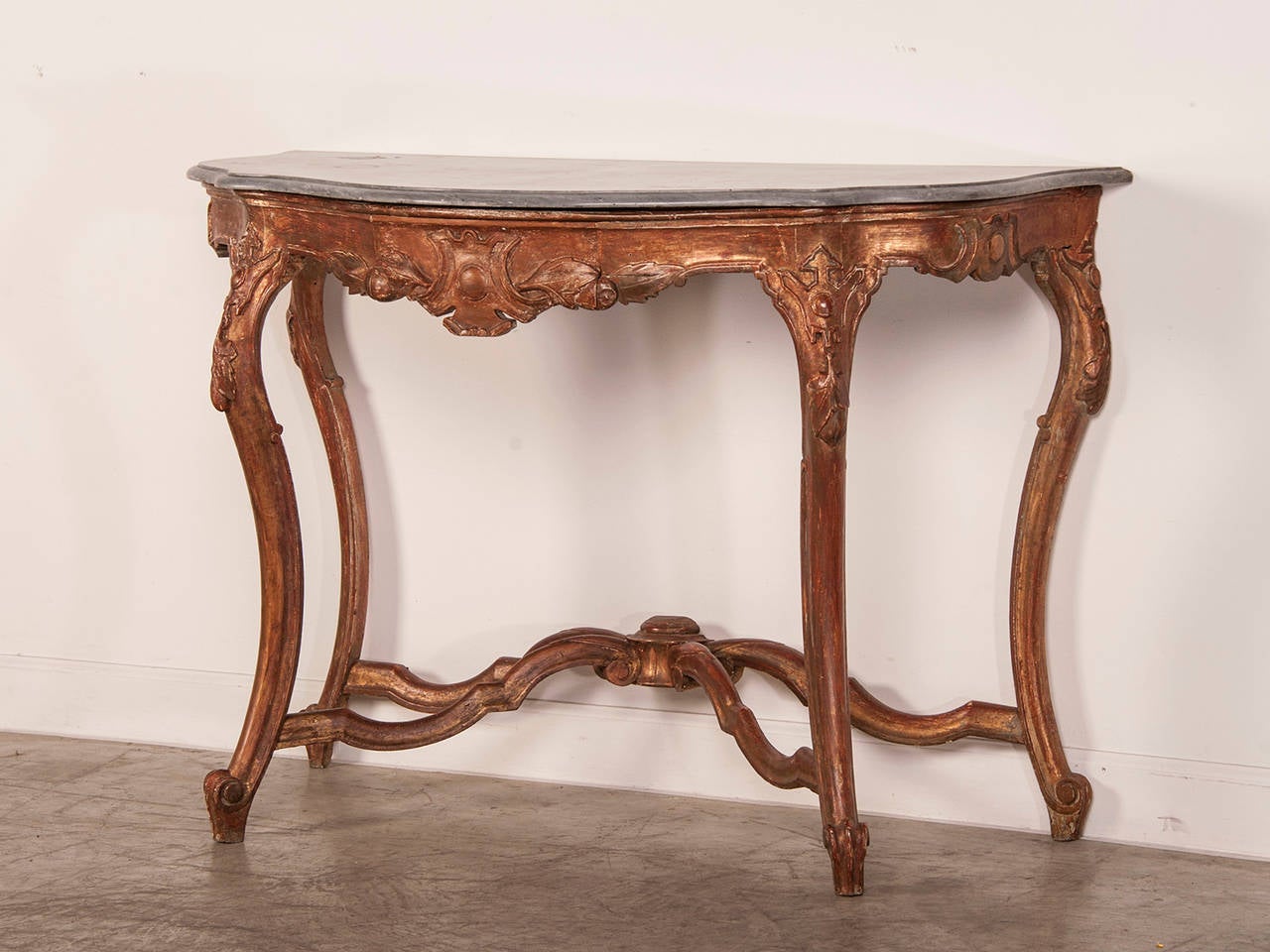 Receive our new selections direct from 1stdibs by email each week. Please click Follow Dealer below and see them first!

An antique French Louis XV style gold leaf console table circa 1810 connected with stretchers and having the original grey