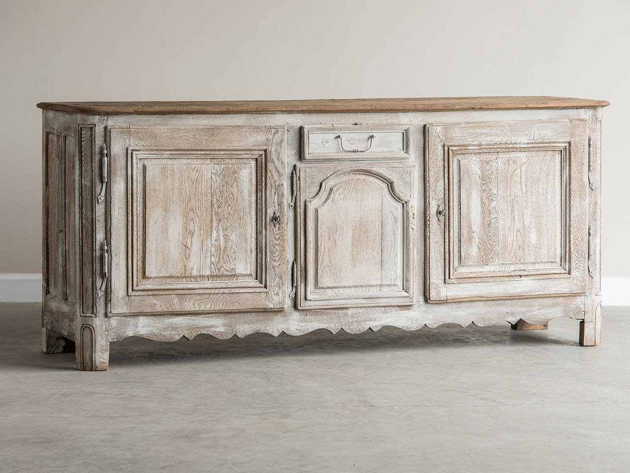 Régence painted oak buffet with three doors, France, circa 1730. The handsome simplicity of this antique French buffet is due to the symmetrical placement of the three cabinet doors with a single drawer in the centre. This elegant balance of the