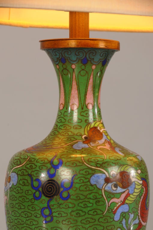 A pair of charming cloisonne vases from France c. 1890 set into carved circular wooden bases and converted to lamps wired for American electricity. The technique of cloisonne, where a raised design of gold wire is filled with various colours of