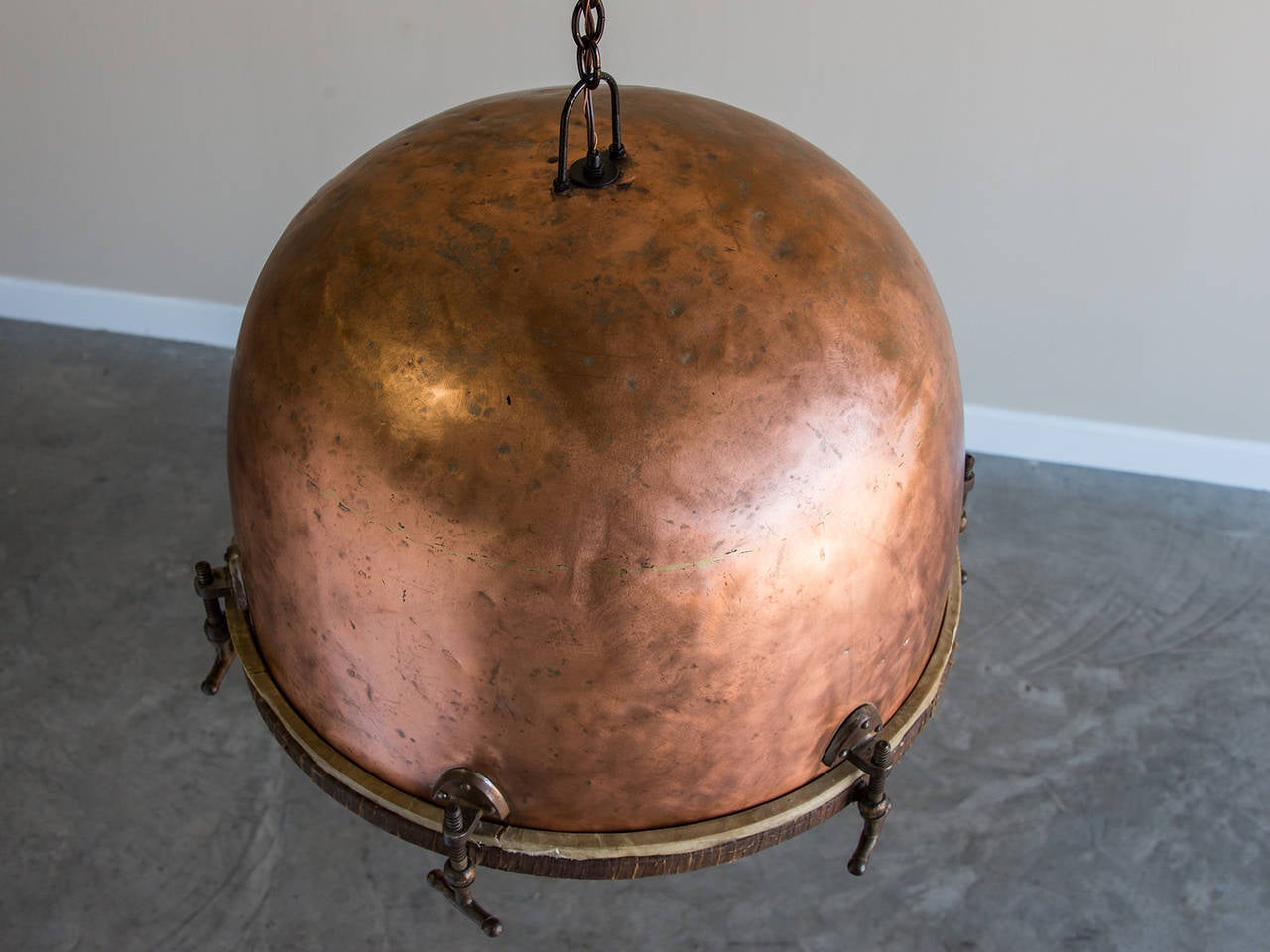 This innovative light fixture used to be a timpani drum in a symphony orchestra. Here it has been turned upside down and suspended from a chain to form a most unusual vintage French chandelier. The hammered solid copper shows the passage of time