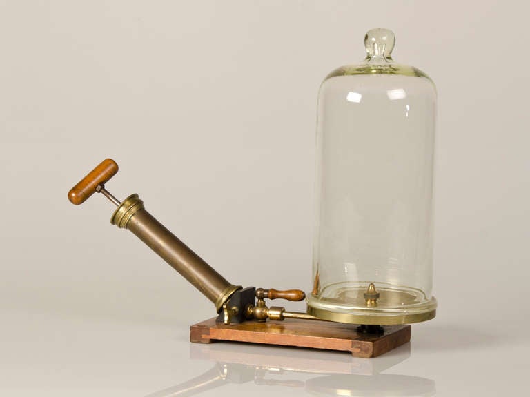 A table top vacuum chamber with the original glass from England c.1885. This wonderful survivor of the scientific process of experimentation is entirely complete as the wooden stand retains both the vacuum pump cylinder to extract the oxygen as well