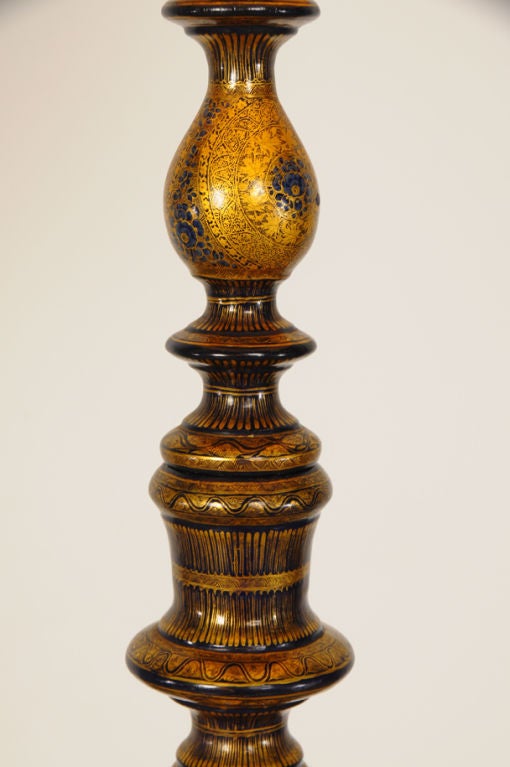 A fabulous Edwardian period lamp standard from England c. 1910 featuring an elaborate Kashmiri pattern of royal blue and gold in a symmetrical design. The circular base is raised slightly on bun feet and has a moulded edge. The surface has a