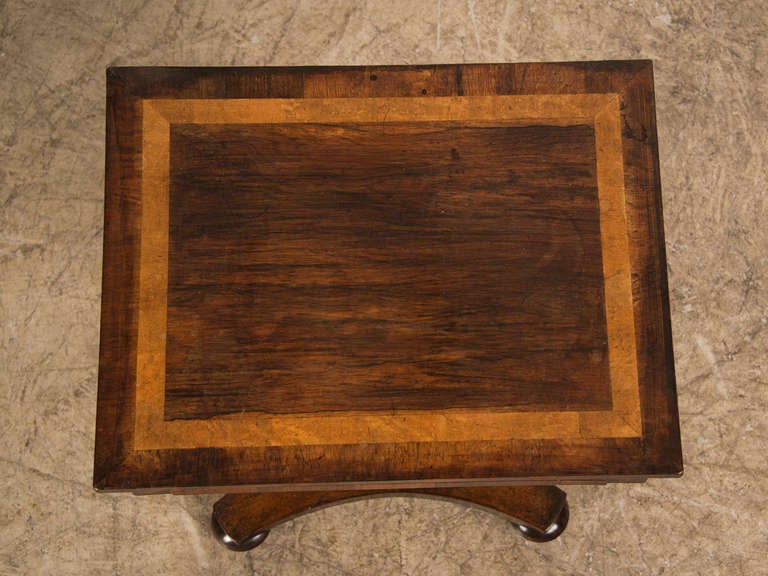 A rectangular William IV period rosewood and walnut pedestal table with a drawer from England c.1835. This unusual table is finished on all four sides as it was designed to be seen from all directions. The striking combination of the highly figred