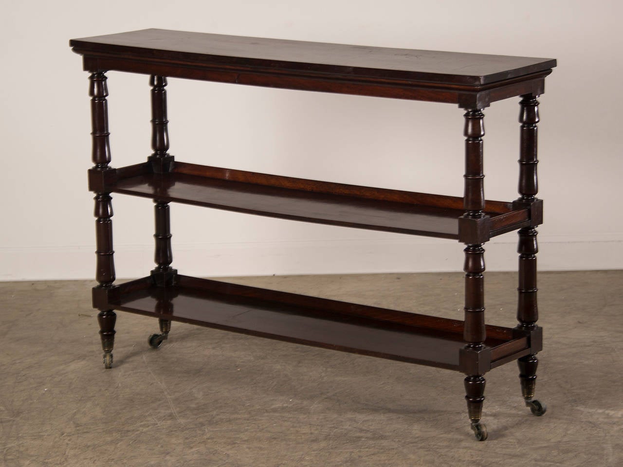 Receive our new selections direct from 1stdibs by email each week. Please click Follow Dealer below and see them first!

A slender antique English mahogany butler's stand or etagere circa 1860 with turned vertical supports standing on the original