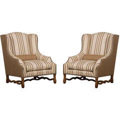 A pair of large wing chairs from France c.1910 with a pale beechwood frame