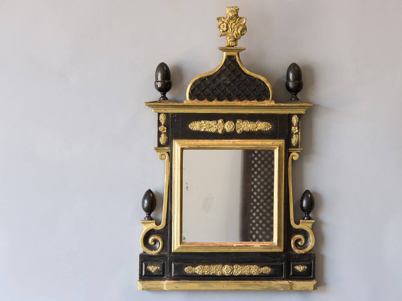 The bold form of this antique Neoclassical Danish mirror, circa 1860 creates a powerful focal point when combined with the striking contrast between the gilded ornamentation and the dark black green painted finish. The central arch is defined by a