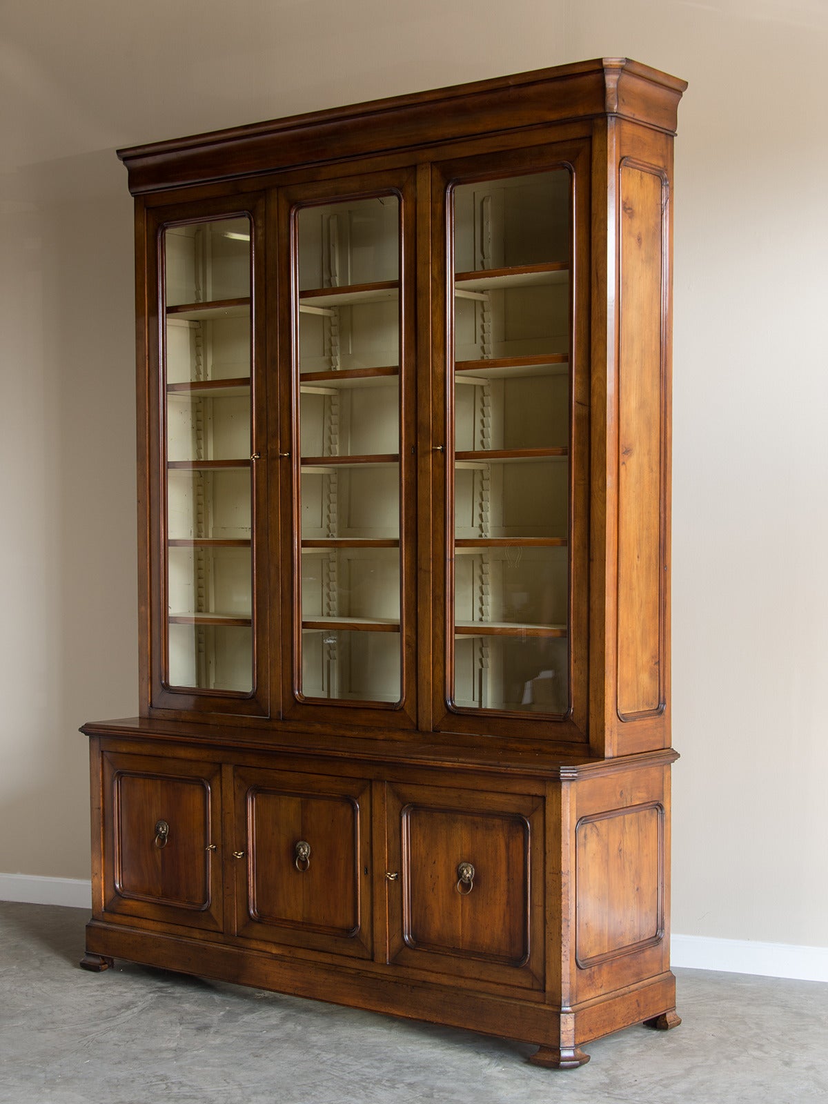 The great scale of this antique French bibliotheque or bookcase is one of its most defining features. Constructed of fine cherrywood and retaining the original glass with its rippled surface the emphasis is on providing ample amounts of display for