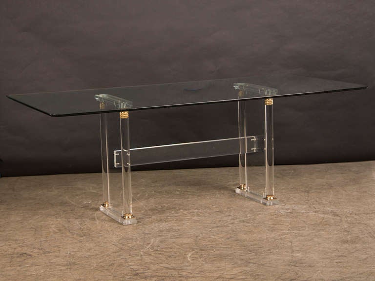 This elegant vintage French Mid-Century Modern dining table circa 1960 base was created entirely from transparent Lucite in the manner of an Empire period original. All four of the columns showcase bronze doré collars at the top and bottom that are
