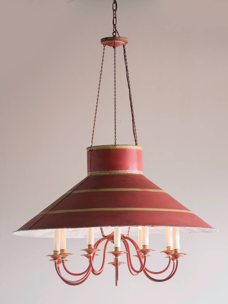 Vintage Tôle Chandelier, Twelve Lights, France circa 1940. This wonderful fixture features the original red painted finish embellished with gilded highlights. The round shape was achieved by using sheet metal because it could be bent into the
