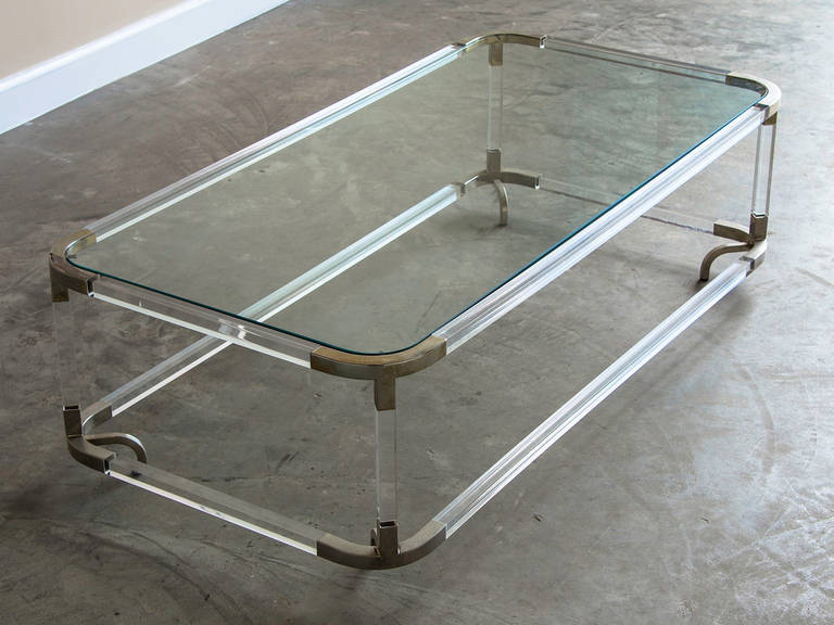 Perspex and metal coffee table with glass, Italy, circa 1975. The curved corners of this particular coffee table and the curved feet that invert toward the centre gives this table its unique appearance. The corners are made of metal with a silvery