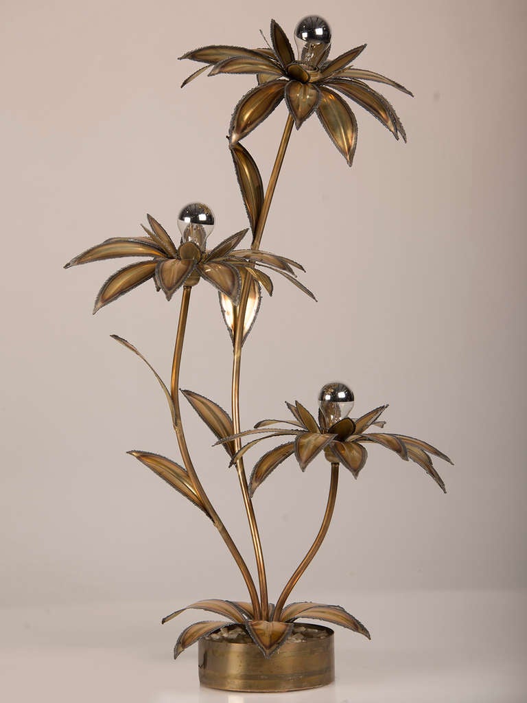 Maison Jansen Style Three Branch Hammered Brass Palm Tree Lamp, France c.1970. This wonderful artifact of 1970's French design is notable for its square base set with pebbles from which the three separate trunks of the palms arch up and outward. The