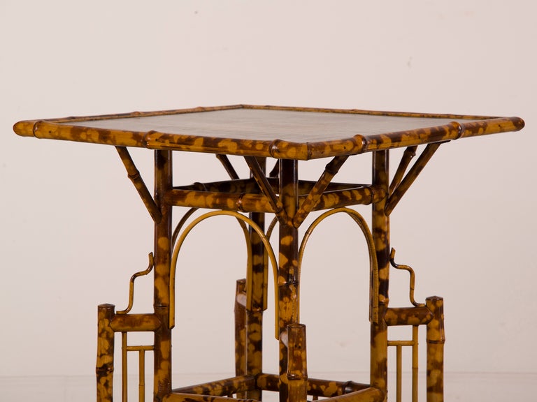 A fantastic scorched bamboo table of elaborate construction from Belle Epoque period France c.1890.  Please look at the fantastical shape of this table with its square top that stands upon a base replete with straight and curved lines that enclose a