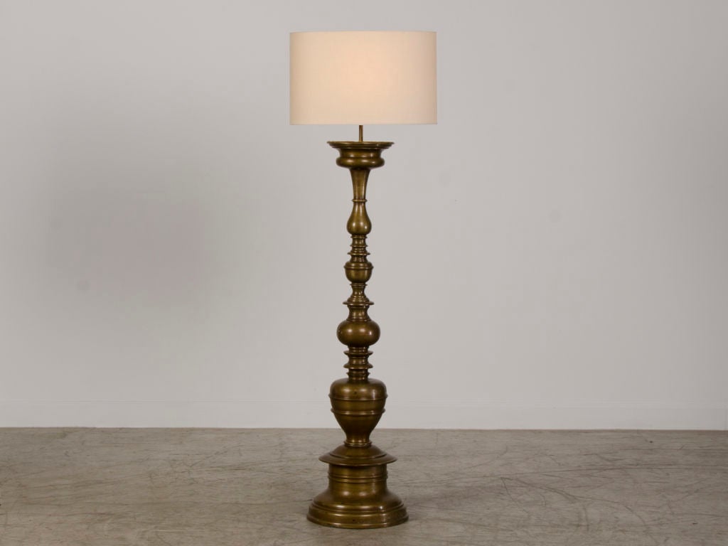 A pair of striking solid bronze candle stands from Italy c.1880 wired as floor lamps. These candle stands are based on the originals first cast during the late 1500's-early 1600's used to illuminate the interiors of palazzos and villas of the