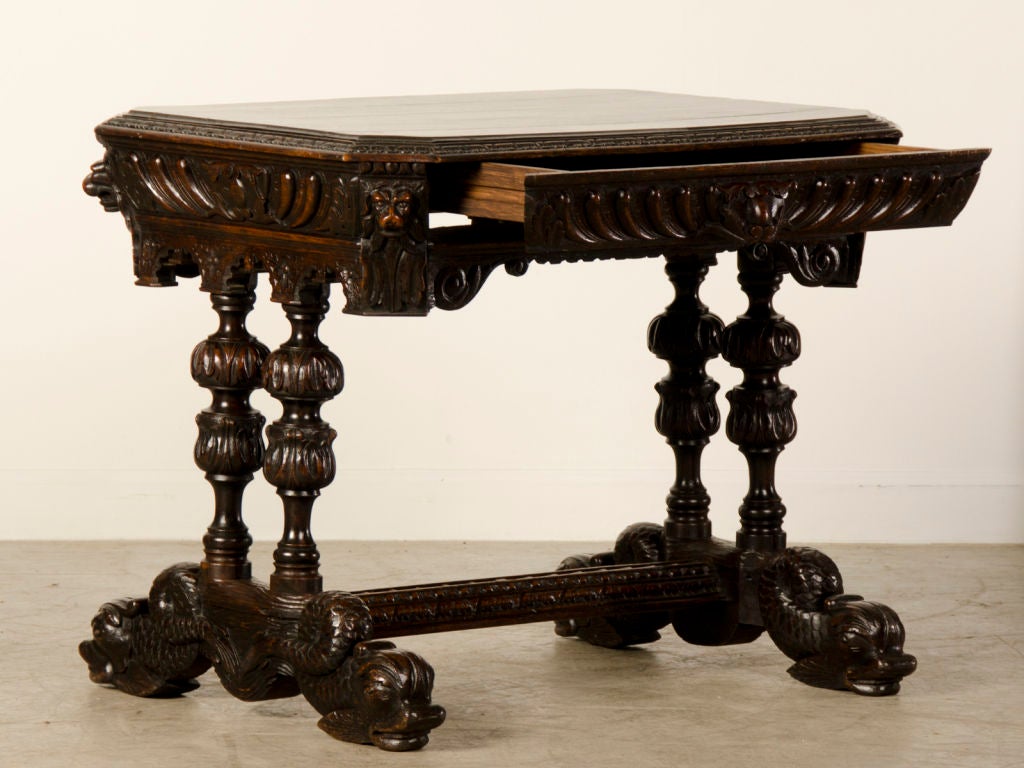 A sensationally carved Renaissance style oak table with a drawer from Italy circa 1880. This table possesses a striking appearance because of the profuse carving seen over every surface that enables the table to be viewed from any direction while