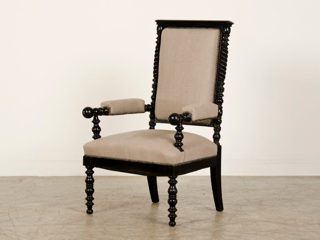 A pair of striking Napoleon III period armchairs from France c.1870 with an ebonized finish now freshly upholstered in Belgian linen. Please take a moment to cast an eye over the superb silhouette these chairs present that has a definite sculptural