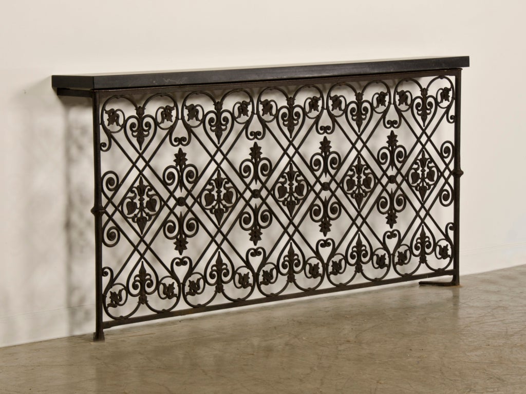 A sensational cast iron balcony railing removed from a villa near Avignon, France that dates to c. 1875. Please notice the enormous scale of this piece with its extraordinary width. The invention of cast iron (as distinct from forged iron, worked by
