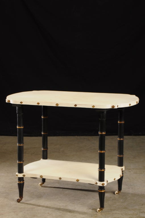 Receive our new selections direct from 1stdibs by email each week. Please click Follow Dealer below and see them first!

A vintage French Art Deco period ebonized wood table circa 1930 with shelves covered in vellum and nailhead trim. Please
