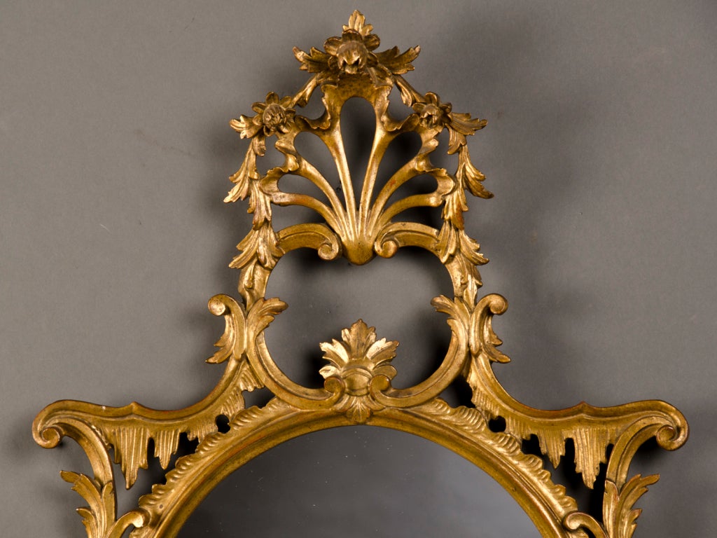 A lavish George II style carved and gold leaf frame enclosing the original oval mirror glass from England c.1865. Please look closely at the wonderfully sensuous quality of this mirror frame with its delightfully curvaceous form. The beautiful