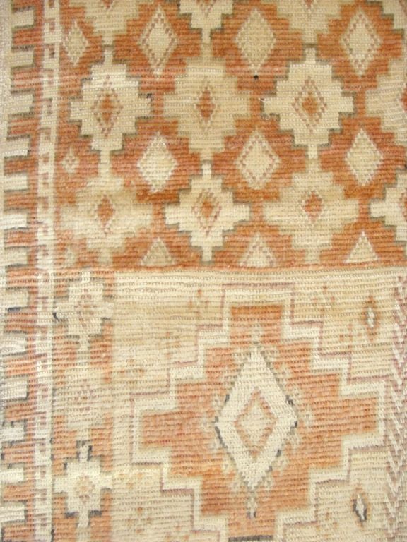 Vintage Moroccan runner with stepped lozenge design in muted coral and ivory tones.