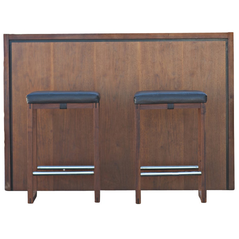 A mid century modern bar from Maurice Villency in New York.  A simple, elegant design in walnut with wine rack, drawers, stoage and built-in ice bucket.  As shown, we also have two matching bar stools available on 1stdibs.