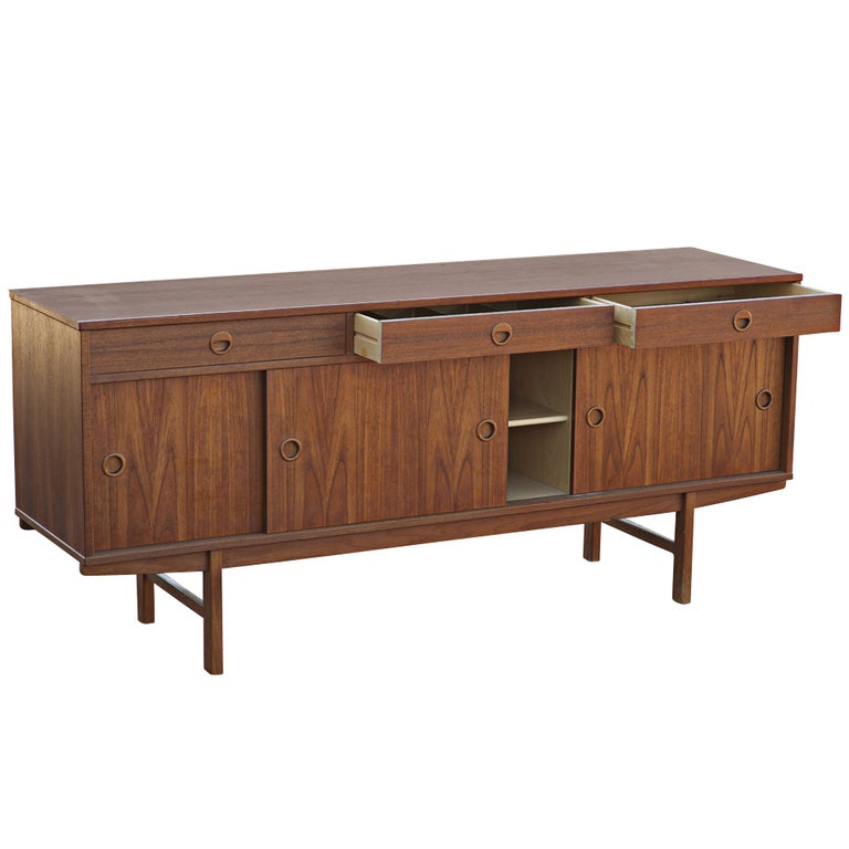 A mid century modern Scandinavian style buffet made by Dux and sold by Maurice Villency in New York.  Beautifully figured teak with three sliding doors and three drawers.