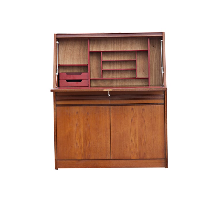 A mid century modern drop front desk with Danish styling.  Teak with a red leatherette writing surface and red fitted interior.