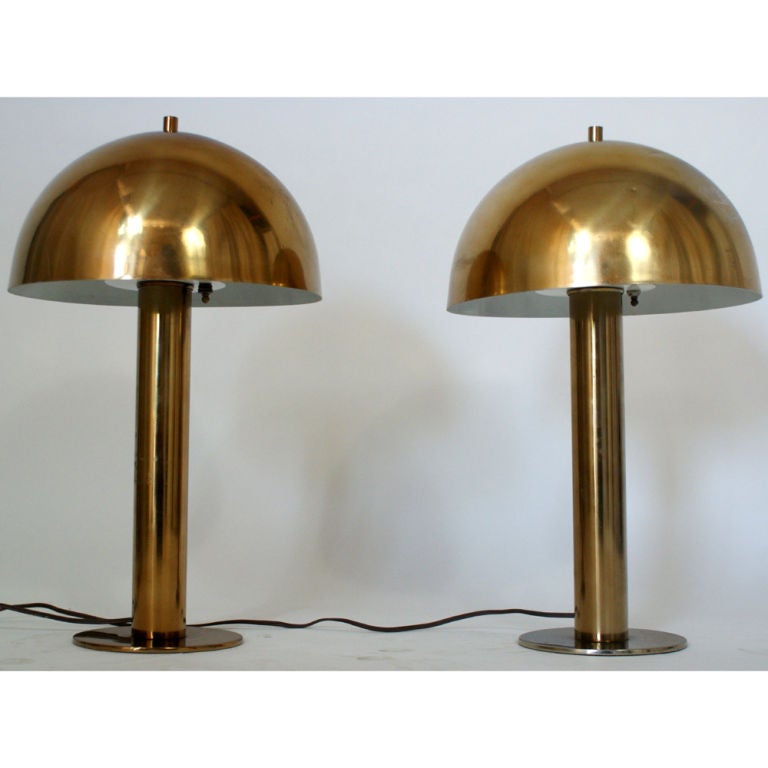 A pair of mid century modern brass lamps with dome shades designed and made by Robert Sonneman.  One small ding to one shade as noted in the last image.