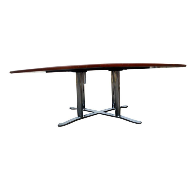 A mid century modern conference table designed by Nicos Zographos and made by Zographos.  A walnut top, eight feet in diameter, with a stainless steel base.  There is an electronics control console in the center of the table.