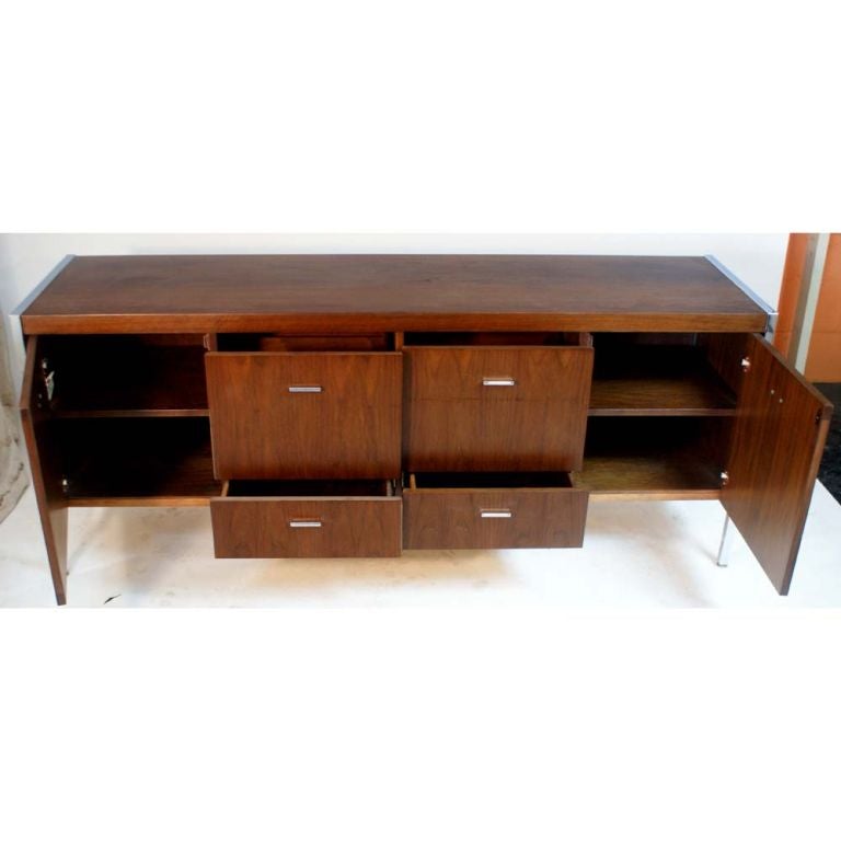 A mid century modern credenza made by Jasper.  A walnut case with chrome frame and legs.  The back is finished so this piece may be used as a room divider.  Two regular drawers, two file drawers and two doors concealing shelved storage.  As shown in