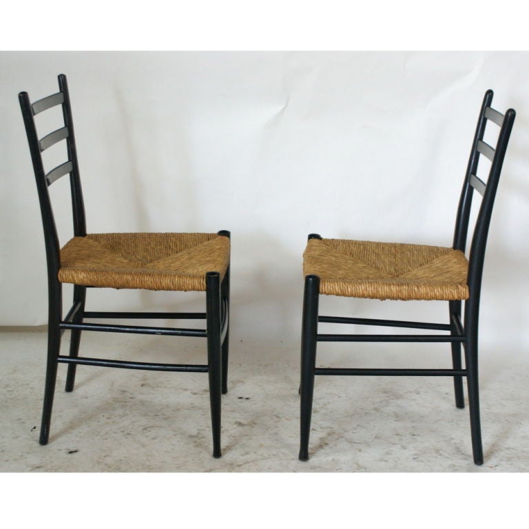 A set of four mid century modern dining or side chairs in the style of Gio Ponti Superleggera chairs.  Made by Otto Gerdau in Italy.  Ebonized wood frames with woven seats.