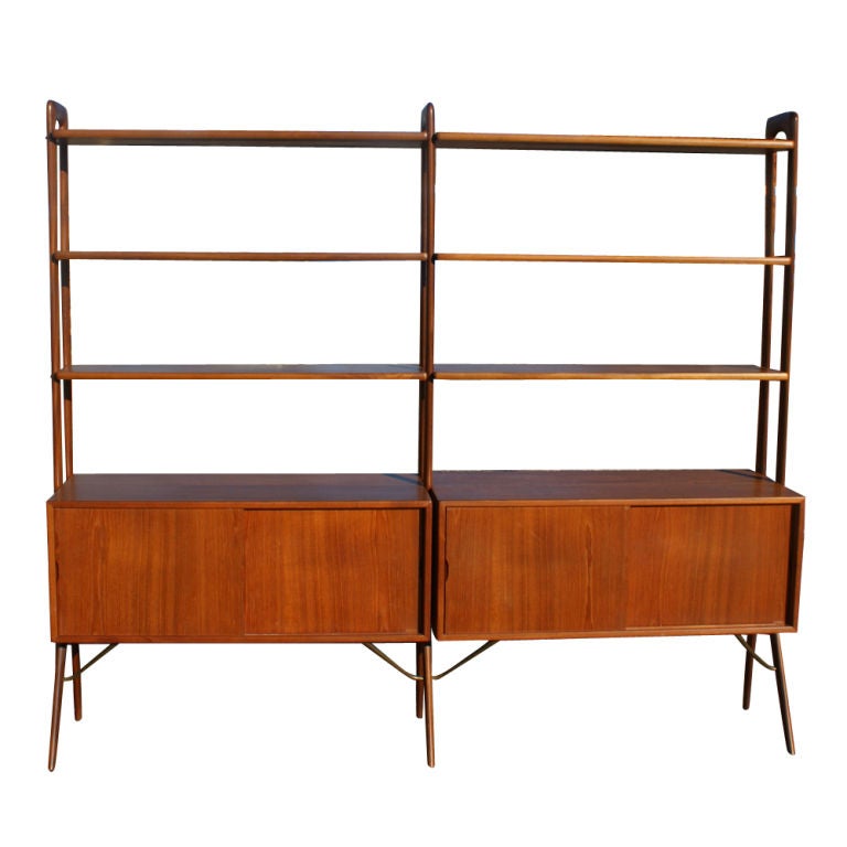 A mid century modern shelving unit designed by Kurt Ostervig and made by France & Son which can also be used as a room divider.  Two cabinets raised on splayed legs and six shelves.