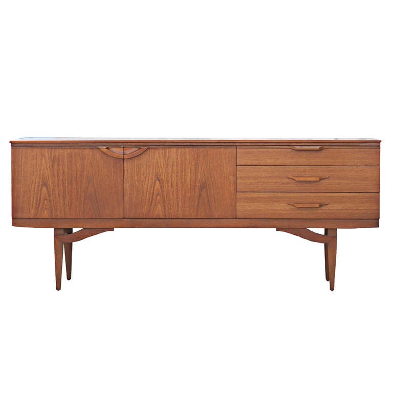 A mid century modern buffet or credenza with lots of style and srorage space. 

Made of teak veneer, the credenza features two hinged doors on the left that open to reveal two separate storage areas, each with an inset shelf.  Next to the double